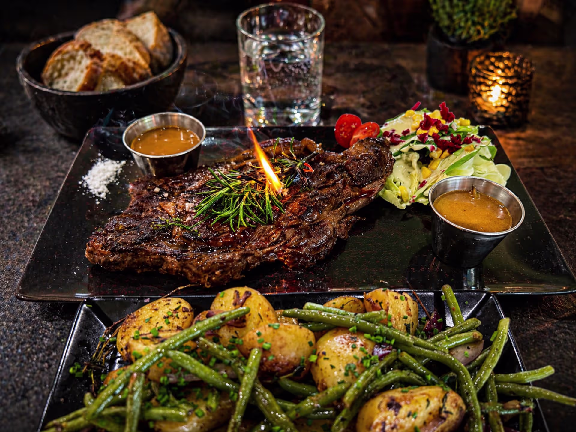 Plat magnifiquement pr&eacute;sent&eacute; avec un grand steak grill&eacute;, garni d'herbes fra&icirc;ches, accompagn&eacute; de pur&eacute;e de pommes de terre cr&eacute;meuse, de haricots verts saut&eacute;s et de sauces dans de petites tasses.