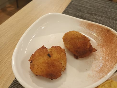 Croquetas doradas y crujientes, rellenas de una mezcla cremosa de queso o patatas.