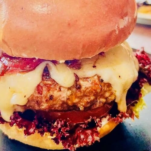 Hamburguesa jugosa con un patty empanizado, queso derretido, lechuga fresca, tomate y salsa rica.