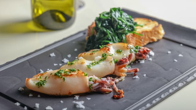 Grilled squids with toasted bread, pink pepper and steamed baby spinach