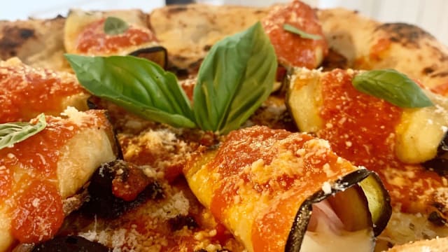 Pizza Parmigiana; Salsa ragu napoletano, rollos de berenjenas fritas con mozzarella y jamon dulce, parmesano rallado.