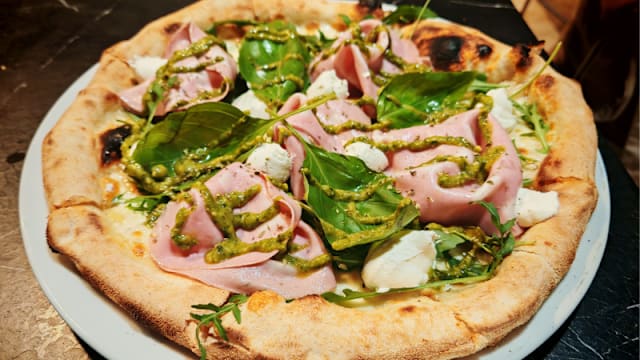 Pizza Mortadella: Mozzarella, mortadella de Bologna, burrata, pesto, rucula, albahaca. 
