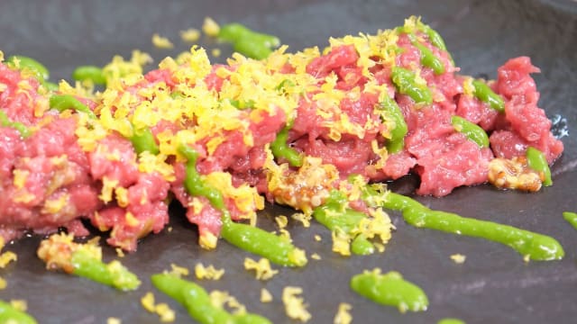 Tartare di scamone di manzo neozelandese condita con senape, acciughe del Cantabrico e capperi, topping di uovo marinato servita con salsa al prezzemolo