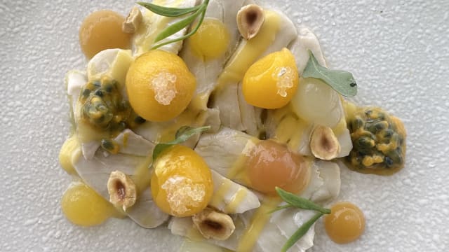 Ricciola marinata agli agrumi con pesca gialla, finger lime, nocciole tostate e frutto della passione