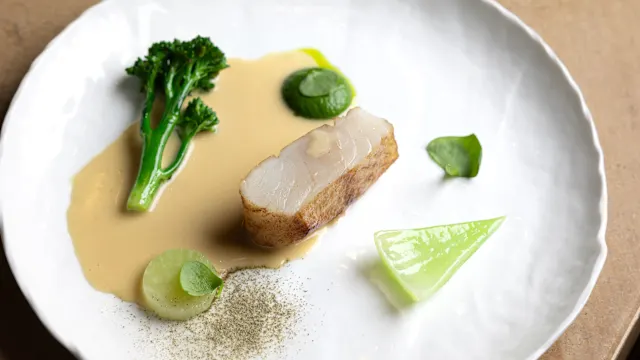 Le lieu jaune de ligne ikejime, légumes verts marinés au dashi, condiment herbes et wasabi, poudre de câpres, beurre blanc à la prune umeboshi  Et sur le côté, une tartelette au bardes de poisson, stracciatella, vinaigre de poisson fumé et feuille de câprier