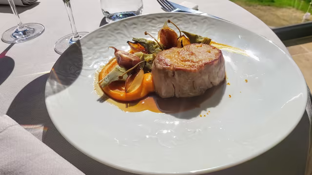 Un filet mignon de porc juteux, accompagné d'une purée de potiron crémeuse et de légumes rôtis, le tout rehaussé d'une sauce savoureuse.