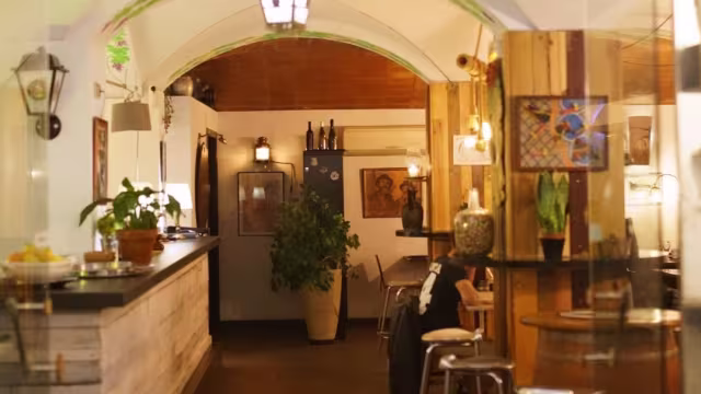 Interior de restaurante acogedor con acentos de madera, iluminación suave y un ambiente invitante, ideal para reuniones informales.