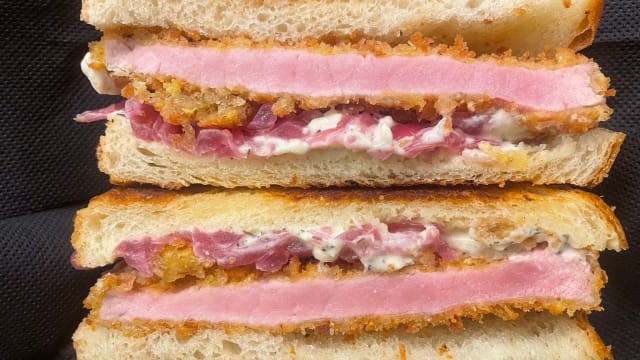 COTOLETTA DELLA NONNA Pan brioche fatto in casa, cotoletta di arista di maiale, cipolle rosse di tropea in agro, salsa alle erbe