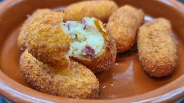 CROQUETAS DE JAMON In qualunque ristorante o bar della Spagna troverai sicuramente le CROQUETAS, un piatto sfizioso, al loro interno è racchiuso un delizioso ripieno di besciamella e prosciutto, ed anche una disputa internazionale sulla loro origine… La “crocchetta” non nasce in Spagna 🇪🇸 , la raggiunge solo alla fine del XIX secolo. Questo aperitivo è nato in Francia 🇫🇷 , dove Louis de Bechamel, Il “padre” delle crocchette lavorava come esattore delle tasse ed era sovrintendente della casa del duca d'Orleans. Si dice che lui o uno dei suoi assistenti abbia creato il besamel, a cui la dedicò, come spesso facevano i cuochi per la nobiltà dell'epoca. Ma fu solo nel 1817, quando il cuoco, Antoine Cámere, servì crocchette à la royale a una cena per l'arciduca di Russia, avendo la brillante idea di ricoprire la besciamella con uno strato croccante. C'è poi anche una teoria italiana 🇮🇹, secondo la quale la “crocchetta” sia stata creata dai cuochi fiorentini di Caterina de' Medici che l'hanno accompagnata al suo matrimonio a Marsiglia con Enrico II d'Orléans nel 1533, essi affermano di essere gli inventori della besciamella. La loro origine quindi non è chiara ma il loro gusto è chiarissimo! 
