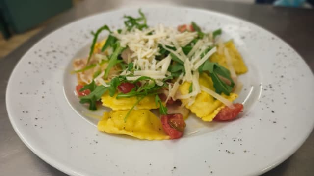 Ravioli cacio e pepe con pancetta, rucola, pachino e scaglie di parmigiano