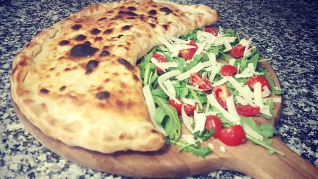 Calzone ripieno con mozzarella, salsa di pomodoro, prosciutto cotto e funghi freschi