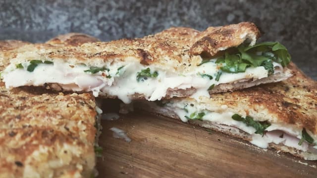 Pizzolo LIGHT con petto di tacchino arrosto, rucola, mozzarella, salsa dressing e pomodorini a crudo