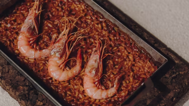 Risotto de mariscos con camarones jugosos, infusionado con azafrán y decorado con hierbas frescas.