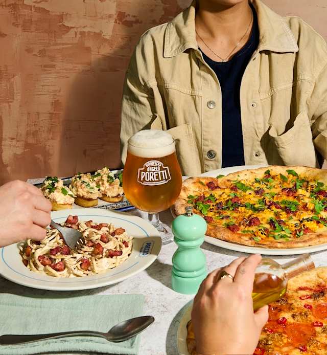 Creamy pasta topped with crispy bacon and herbs, alongside a colorful pizza with bell peppers and olives, and small appetizers resembling bruschetta.