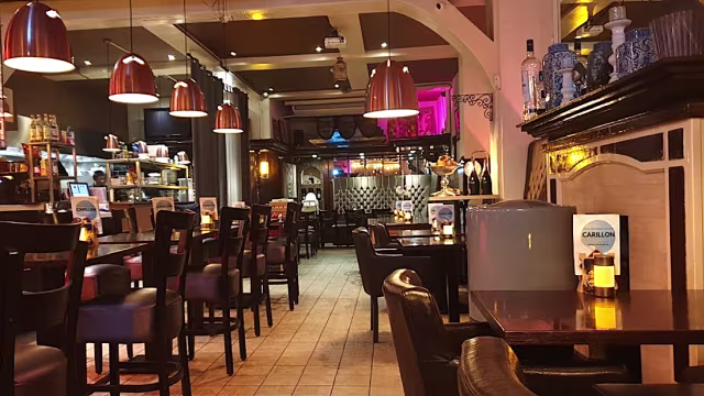 Het restaurant heeft een warme en uitnodigende sfeer met houten meubels en zachte verlichting, ideaal voor zowel casual dineren als sociale bijeenkomsten.