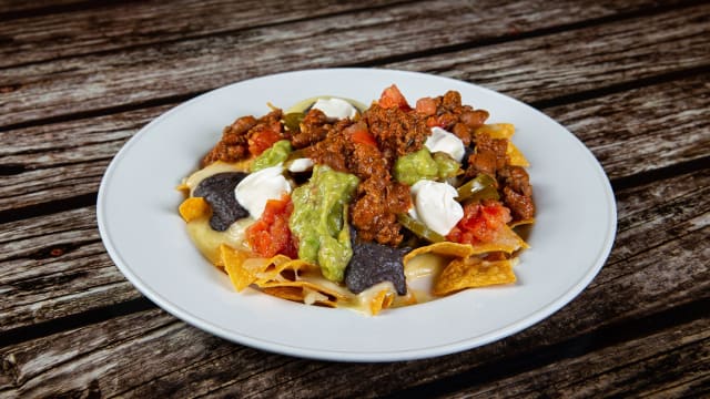 Chips di mais, chili con carne, formaggio, guaiamole, purea di fagioli, pico de gallo e tour cream