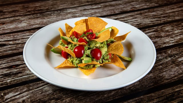 Guacamole. Avocado, cipollotto, pomodoro, lime, peperoncino, coriandolo servito con chips di mais