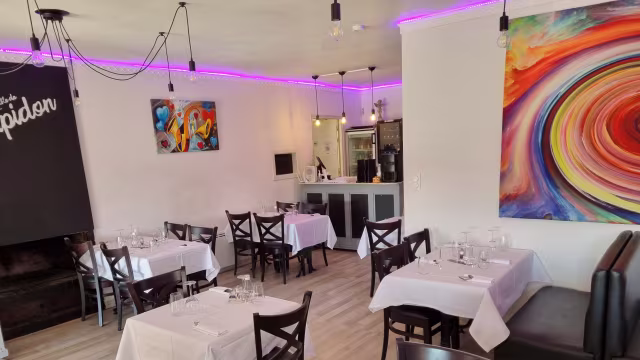 Intérieur moderne et accueillant avec des murs blancs, des œuvres d'art colorées, un éclairage contemporain et une ambiance élégante.