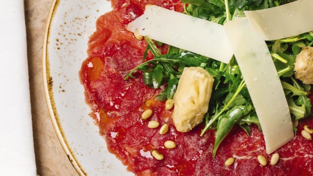 Carpaccio di Manzo, com alcachofra, pinhões, Grana Padano e azeite de trufa.
