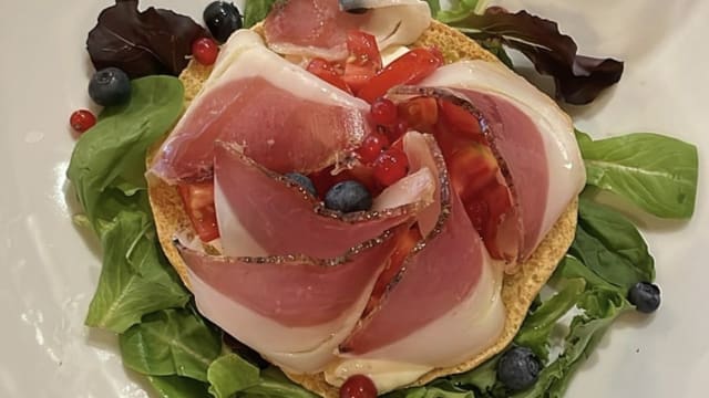 Fresella con stracciatella di bufala, pomodorini e filettuccio di nero di calabria