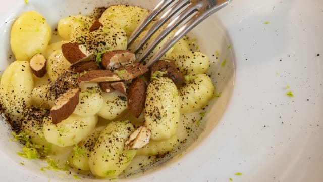 Gnocchi, crema di parmigiano, mandorle tostate, aglio nero e lime 