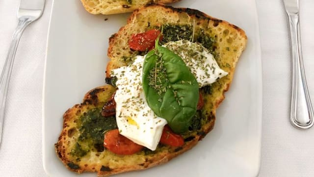 Crostone di Pane Nero alle Noci con Burrata di Bufala e Datterino Confit