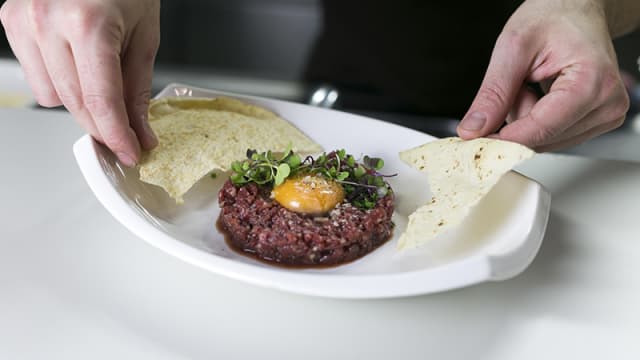 Tartar de ternera - Picamos muy fino la parte del lomo, aliñado con chalotas, soja, cítricos y un ligero toque de wasabi. Acompañado de un fino pan de carasau.