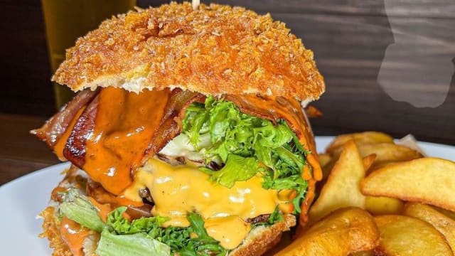 Un’esplosione di gusto: hamburger gourmet con panatura croccante, bacon croccante, formaggio fuso e salsa BBQ. Il perfetto equilibrio tra croccantezza e sapore per un’esperienza indimenticabile.