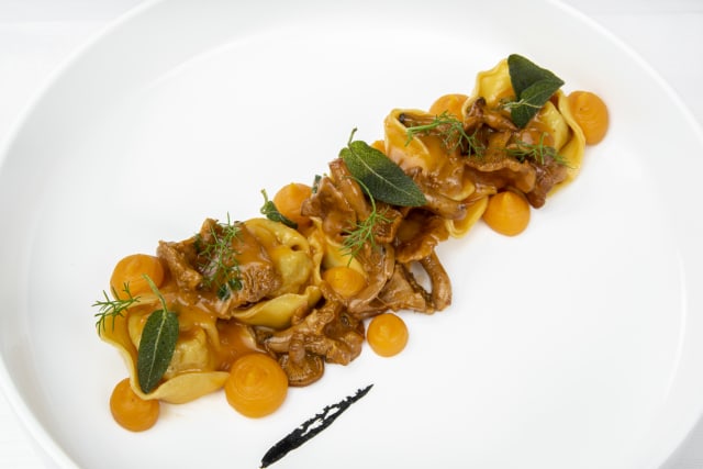 Cappellacci chiusi a mano  ripieni di baccalà, finferli e patate abbinati ad una crema dolce di zucca al timo e finferli di bosco spadellati.