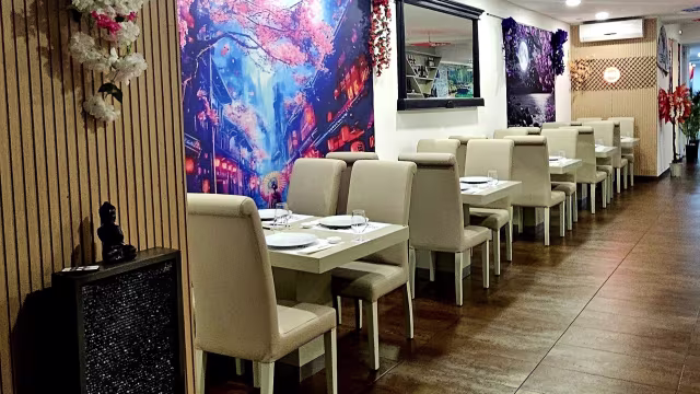 Interior moderno com painéis de madeira clara e assentos em bege suave, decorado com murais coloridos de cenas noturnas, criando uma atmosfera vibrante e acolhedora.