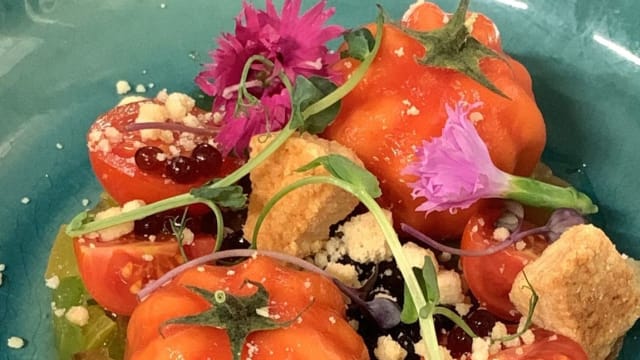 Entrée Dîner : Tomate surprise, bonbon coulant à la stracciatella, jardin de tomates de saison,  amandes, parmesan croustillant, perles de vinaigre balsamique