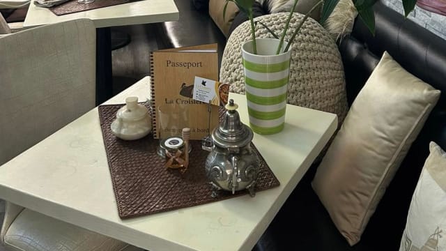 Ambiance chaleureuse d'un restaurant avec une table décorée, un menu intitulé "Passport" et divers accessoires élégants.