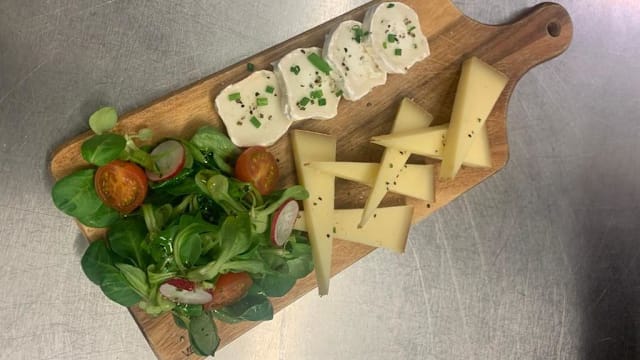 Sélection d'ingrédients frais comprenant des tranches de fromage crémeux et un mélange de salade avec des feuilles vertes, des tomates cerises et des radis.