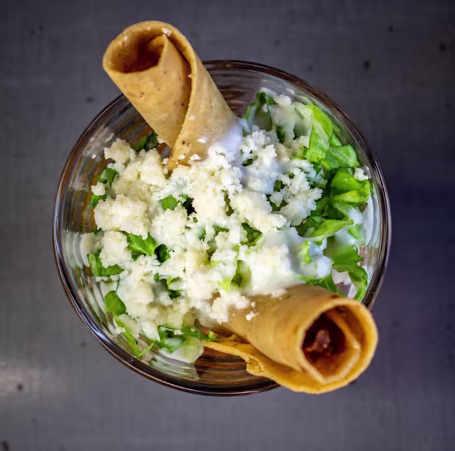 FLAUTAS: Tortilla frita rellena de pollo, sobre salsa verde, lechuga, crema agría y queso (3u)