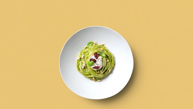 Spaghetti al pesto di basilico, stracciatella, pinoli tostati, pomodori secchi, basilico