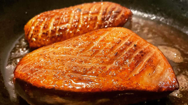 Perfect gebakken eendenborst met een krokante, goudbruine huid en sappig, mals vlees, geserveerd als een rijk en decadent hoofdgerecht.