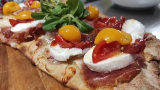 Pinsa con mozzarella di Bufala, prosciutto crudo di Parma, pomodorini tricolore