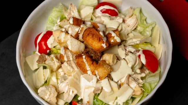 Caesar salad - Insalata Iceberg, succulento petto di pollo cotto a bassa temperatura, crostoni di pane, scaglie di Grana Padano DOP e salsa Caesar 