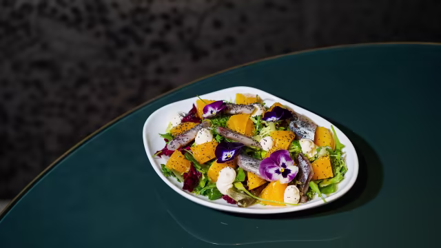 Ensalada de sardina ahumada, mezclum, naranja Pérsica, emulsión cítrica y semillas de amapola