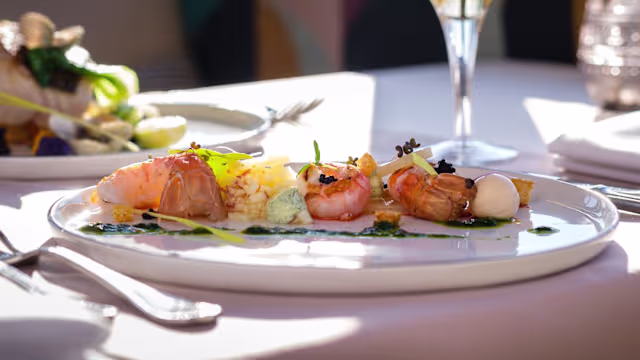 Sélection de fruits de mer élégamment présentée, comprenant des crevettes juteuses et des morceaux de poisson tendre, accompagnée de riz léger aux herbes et de sauces crémeuses.