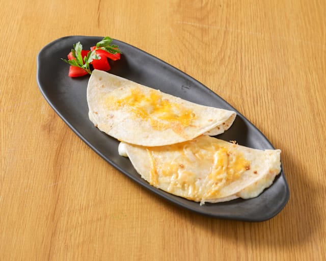 Quesadillas rellenas de queso derretido, acompañadas de tomates cherry y perejil fresco.