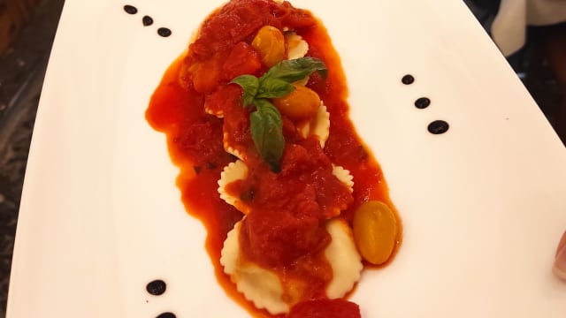 Ravioli ripieni di burrata, fior di latte e patate con pomodorini gialli e rossi profumati al basilico