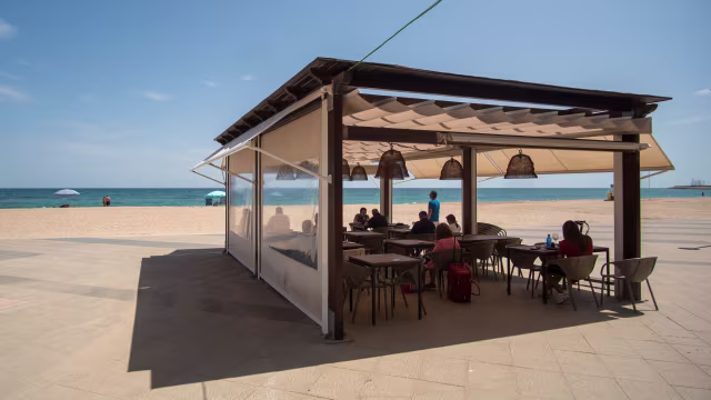 Restaurante junto a la playa con diseño moderno y al aire libre, ideal para una experiencia gastronómica casual con vistas al océano.