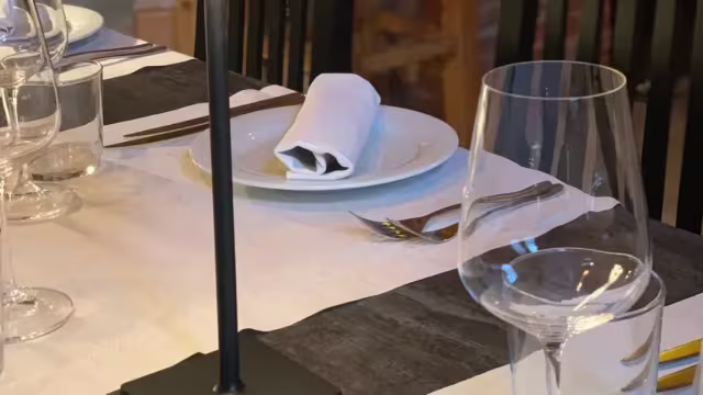 Impostazione elegante di un tavolo da pranzo, pronta per un'esperienza culinaria raffinata.
