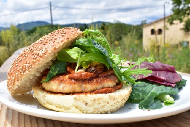 Hamburguesa de pollo con brotes verdes, frutos secos, albahaca y salsa de calçots