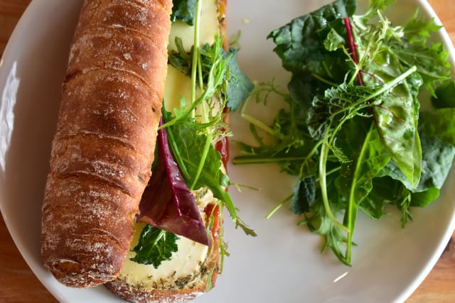 Bocadillo de brotes verdes, berenjena ahumada, queso, mermelada de tomate y nueces
