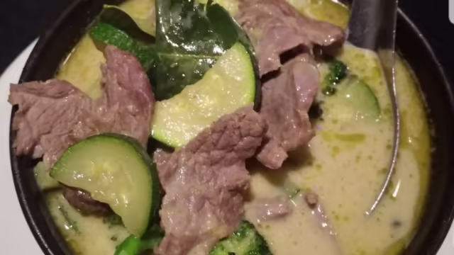 Sopa cremosa de coco con carne de res, calabacín y brócoli, realzada con hierbas aromáticas.