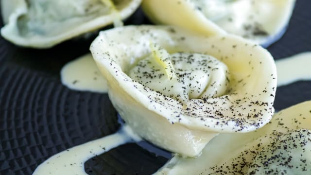 Ravioli di nostra produzione ripieni di gallinella e spinaci, fonduta di roma di pecora Brigasca, olio all'aneto, limone candito, polvere di cipolla bruciata