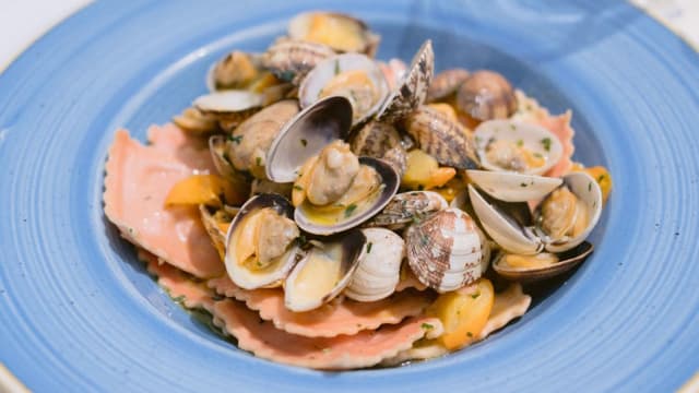 Ravioli ripieni di patate e baccalà, con salsa alle vongole e pomodorini gialli