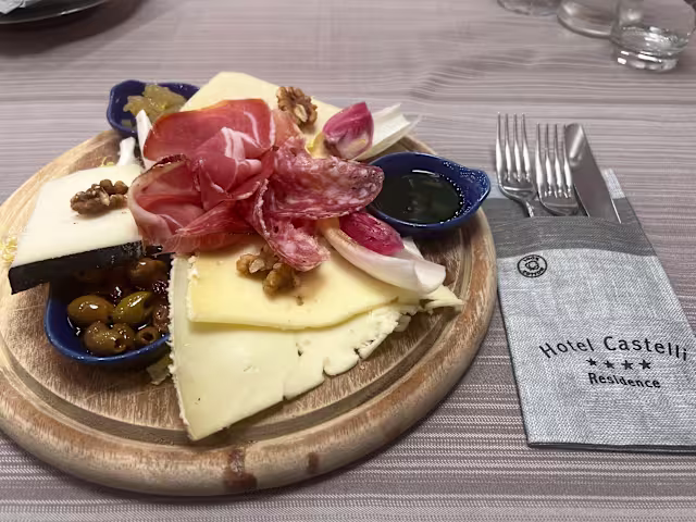 Tagliere di salumi e formaggi servito con miele e marmellata di agrumi